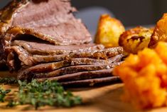 sliced roast beef, potatoes and parsley on a cutting board