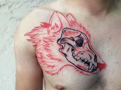 a man's chest with a tattoo of a wolf head and flames on it