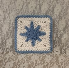 a crocheted blue and white square with a star on it's center