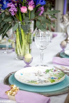 the table is set with purple and blue flowers