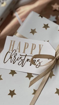 a gift wrapped in white paper with gold stars around it