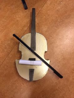 the violin is made out of paper and has two black sticks sticking out of it