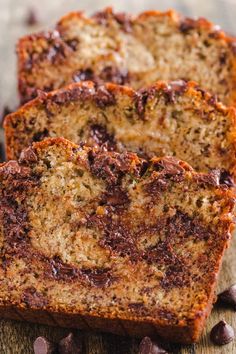 two slices of chocolate chip banana bread on a cutting board next to some chocolate chips