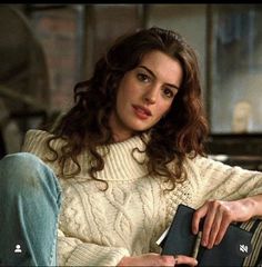 a woman sitting on top of a couch holding a book