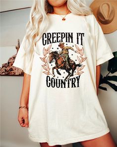 Celebrate Halloween with a western twist in our Cowboy Halloween Shirt for Women! This cute cowgirl fall shirt combines the charm of a pumpkin tee with a stylish western aesthetic, perfect for adding a unique touch to your autumn wardrobe. Made from high-quality Comfort Colors fabric, this autumn graphic tee offers comfort and durability, ensuring you stay cozy and fashionable throughout the season. Whether you're heading to a Halloween party or enjoying a fall day out, this shirt is a must-have Cowboy Halloween, Halloween Cowboy, Cute Cowgirl, Autumn Wardrobe, Western Aesthetic, Great Gifts For Women, Aesthetic Cute, Autumn Coffee, Cow Girl