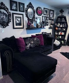 a living room filled with black furniture and pictures on the wall above it's shelves