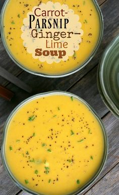 two bowls of carrot parsnip ginger lime soup on top of a wooden table