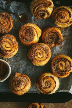 cinnamon rolls on a baking sheet with dipping sauce