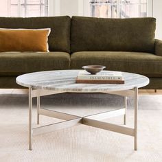 a coffee table with a book on it in front of a couch