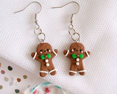 a pair of gingerbread man earrings with candy on them