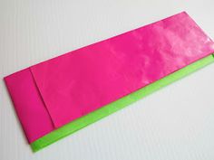 a pink and green piece of paper sitting on top of a table