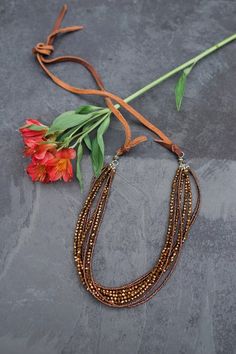 Need an eye catching piece that sparkles in the sunlight? Look no farther! This stunning brown crystal necklace has glass brown seed beads and brown "crystals" that make up a total of 8 strands on a sturdy leather cord. Makes a wonderful statement piece for those extra special occasions. This necklace was constructed in Thailand by at-risk and rescued women.  Dimensions: 52.5" L . Bohemian Brown Beaded Necklaces With Faceted Beads, Bohemian Brown Beaded Necklace With Faceted Beads, Bohemian Brown Jewelry For Parties, Brown Beaded Necklace With Faceted Beads For Gifts, Adjustable Brown Beaded Necklaces, Brown Bohemian Jewelry For Party, Bohemian Style Brown Necklace For Party, Brown Bohemian Party Necklaces, Brown Beaded Necklaces For Parties With Polished Beads