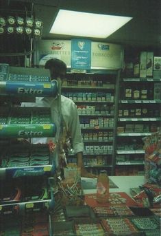 a man standing in front of a store filled with items