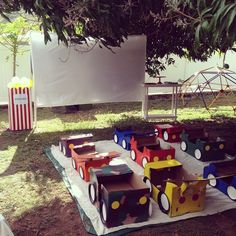 a bunch of boxes that are sitting on a blanket in the grass under a tree