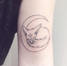 a tattoo on the arm of a woman that has a cat sleeping in a circle