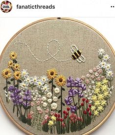 an embroidery pattern with flowers and a bee on it