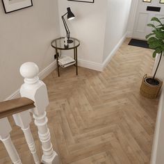 a white staircase with wood flooring next to a potted plant on the side table