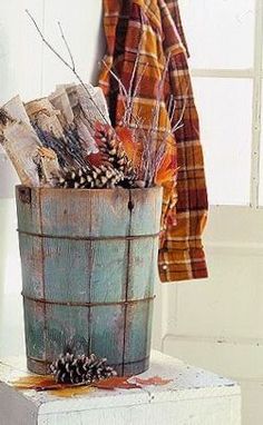 a bucket filled with pine cones sitting on top of a white door