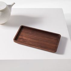 a wooden tray sitting on top of a table next to a teapot and cup