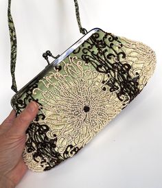 "Vintage Purse Santi Beaded Bag This gorgeous beaded bag was named The FIJI and was made in India for SANTI. This purse is a made out of a pale mint green satin or silk and is covered with an exquisite tropical pattern in pearly white and chocolate brown beads. The pattern looks like an underwater flower garden wonderful and wild with intwined curlicues and scrolls! The intricate floral beading is all over and reverses in color from front to back.  The frame is a shiny deep bronze metal color with a kiss clasp accented with two sparkling rhinestones. The interior is a very pale creamy yellow satin with one zippered pocket and one one sewn in pocket that has the signature blue and yellow fabric tag. There is a fabric handle that matches the fabric and pattern on the purse.  Measures 11\" x Green Beaded Rectangular Evening Bag, Green Beaded Evening Shoulder Bag, Evening Green Beaded Shoulder Bag, Green Vintage Shoulder Bag For Party, Vintage Green Shoulder Bag For Party, Green Embroidered Evening Bag, Elegant Green Embroidered Shoulder Bag, Green Beaded Evening Bag, Elegant Green Beaded Shoulder Bag