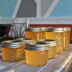 several jars are lined up on a table