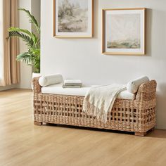 a wicker bench with two pictures on the wall