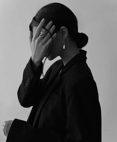 a black and white photo of a woman covering her eyes