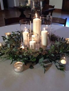 a table with candles and greenery on it