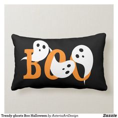 a black and white pillow with two ghost heads on it's side, which says boo