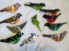 six colorful bird shaped candy wrappers sitting on top of a white bed spreader