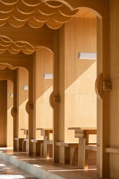 an empty room with wooden columns and benches