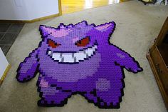 a purple pixel art piece sitting on the floor