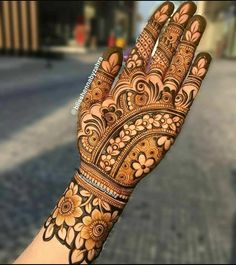 the hand is decorated with henna and flowers