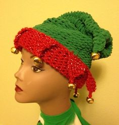 a mannequin head wearing a green and red knitted hat with gold bells