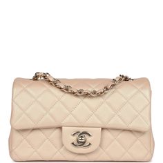 This Chanel mini classic rectangular flap bag is of iridescent beige lambskin leather with light gold tone hardware and has a front flap with signature CC turnlock closure, rear half moon pocket, single interwoven iridescent beige leather and light gold chain link shoulder/crossbody strap.The interior is lined in iridescent beige leather and features a zipper pocket with Chanel pull and an open pocket below.Collection: 22C (RFID Chip)Origin: FranceCondition: New and never worn (plastic on hardware)Accompanied by: Chanel box (damaged), Chanel dustbag, felt and COA cardMeasurements: 8" width x 5" height x 2.5" depth; 20" strap drop Luxury Beige Double Flap Bag, Luxury Beige Flap Bag With Cc Turnlock Closure, Luxury Beige Flap Bag, Luxury Beige Double Flap Shoulder Bag, Beige Rectangular Flap Bag With Cc Turnlock Closure, Elegant Beige Flap Bag With Cc Turnlock Closure, Beige Double Flap Leather Bag, Chanel Mini Rectangular, Chanel Box