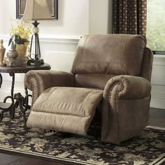 a recliner chair in a living room with a rug on the floor