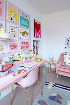 a room with pink furniture and pictures on the wall