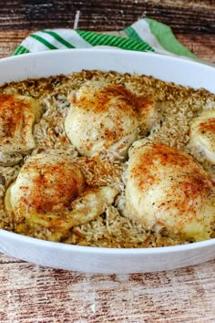 chicken and rice in a white dish on a wooden table