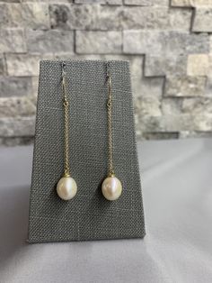 White Pearl 14K Gold Dangle Earrings. The pretty dangle style pierced earrings feature 2 ea White Freshwater Pearl drop shape 11 X 9.5mm AAA high luster with 14 K yellow gold chain dangles (1.3mm) and 14K yellow gold french hook ear wires. They measure 2 3/8 inches from the top of the ear wires. These pearls are beautiful and their luster and overtones are hard to capture in a photo. They are paired with quality solid gold findings. These are hand crafted in our studio. 14k Gold Dangle Linear Earrings With Pearl Drop, Classic Dangle Earrings With High Luster, Yellow Gold Briolette Pearl Earrings For Formal Occasions, 14k Gold Dangle Pearl Earrings, Elegant Hypoallergenic Briolette Earrings, Formal White Gold Drop Linear Earrings, Classic Long Drop Hypoallergenic Jewelry, Classic Hypoallergenic Long Drop Jewelry, 14k Gold Linear Dangle Earrings With Pearl Drop