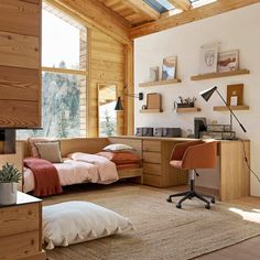 a bedroom with a bed, desk and chair in it's corner area next to a window