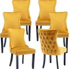 four yellow chairs with black legs and buttons on the back, all facing different directions