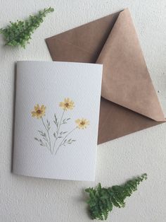 a card with yellow flowers on it next to an envelope