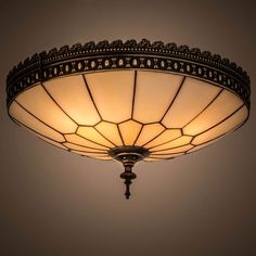 a light fixture with an intricate design on the top and bottom part, hanging from a ceiling