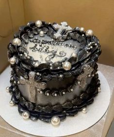 a black and white cake with pearls on it