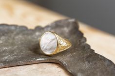 A beautiful signet ring with carvings on the sides made by hand and a mother-of-pearl gemstone in the center. *real images of the ring, taken by us* Mother of Pearl Stone Size: 14x12mm Material: - Sterling Silver 925 - 9K Gold (375) - 14K Gold (585) - 18K Gold (750) *All signet rings are hallmarked on the back for certification* - We offer FREE Worldwide DHL & FedEx Shipping! - Branded DanelianJewelry Gift Box with each order! Our customer service is available 7 days a week. Leave us your messag Signet Ring For Men, Oval Signet Ring, Signet Rings, Gold Signet Ring, Ring For Men, Ring Oval, Natural Pearl, Pearl Gemstone, Natural Pearls