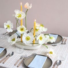 the table is set with white flowers and silverware