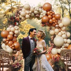 a bride and groom standing under an arch made out of balloons in front of them