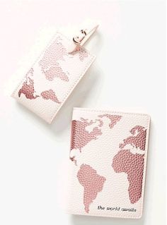 the world awaits passport holder and keychain are shown on a white surface