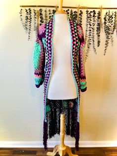 a white mannequin wearing a multicolored cardigan