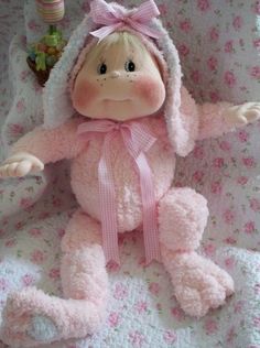 a pink stuffed animal sitting on top of a bed